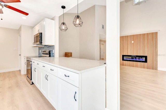 kitchen featuring white cabinetry, ceiling fan, hanging light fixtures, appliances with stainless steel finishes, and light wood-type flooring