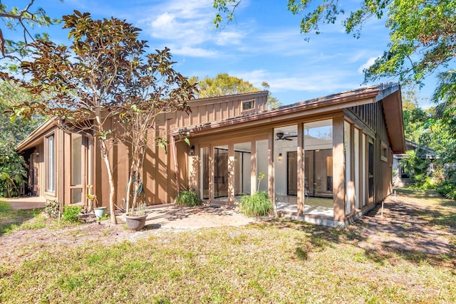 rear view of property featuring a lawn and a sunroom