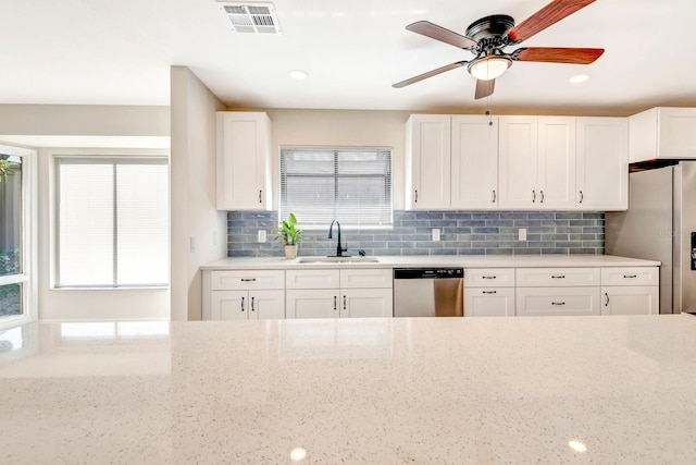 kitchen with sink, white cabinetry, stainless steel appliances, and a wealth of natural light