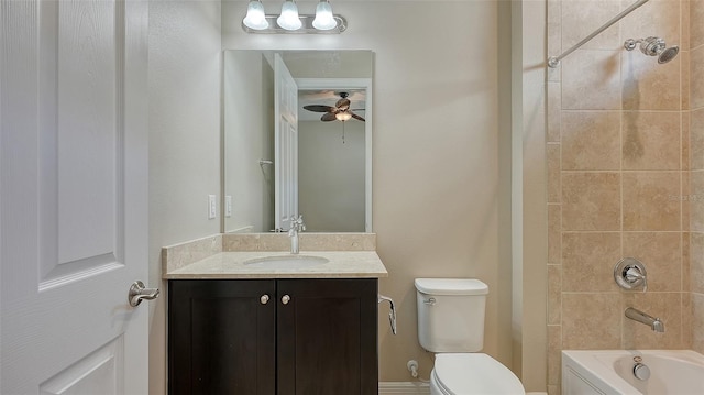 full bathroom featuring tiled shower / bath, ceiling fan, vanity, and toilet