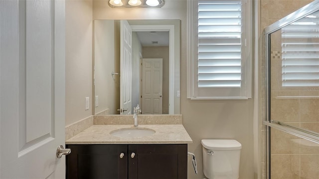 bathroom with vanity, an enclosed shower, and toilet