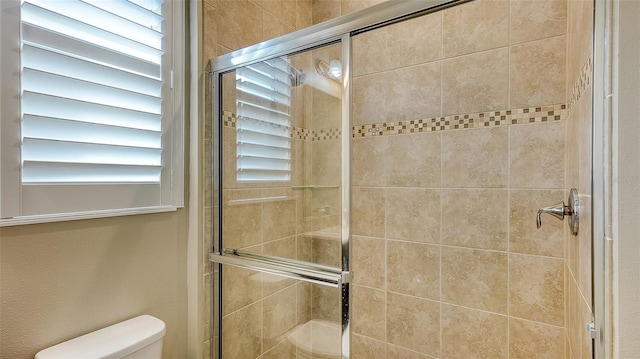 bathroom with toilet and an enclosed shower