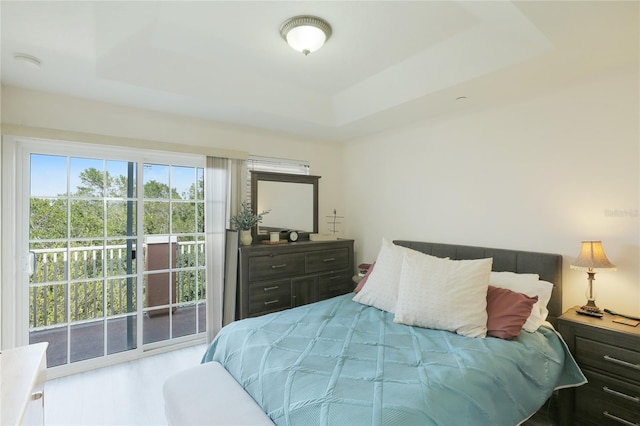 bedroom featuring a raised ceiling and access to exterior