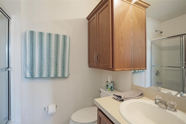 bathroom with vanity, toilet, and a shower with shower door