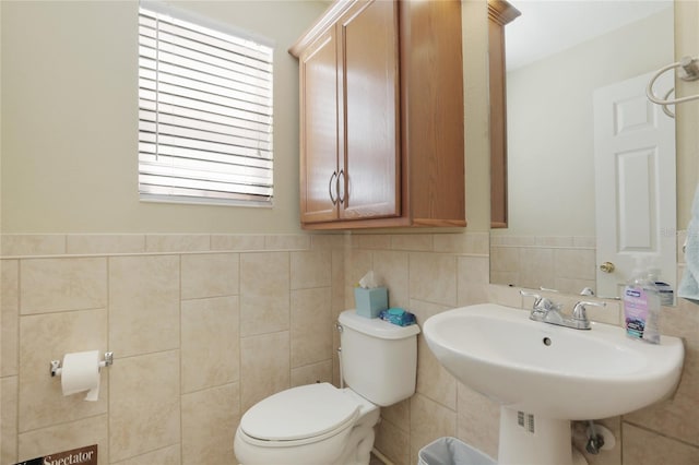 bathroom featuring sink, toilet, and tile walls