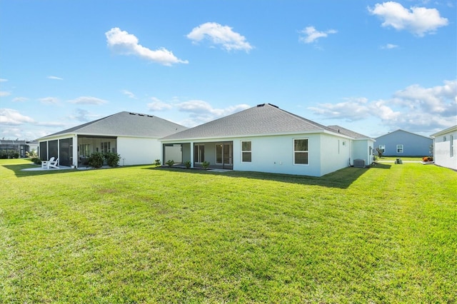 rear view of property with central air condition unit, a lawn, and a sunroom