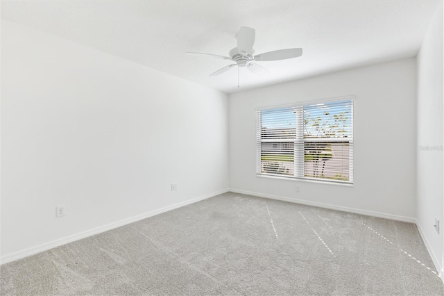 spare room featuring ceiling fan and light carpet