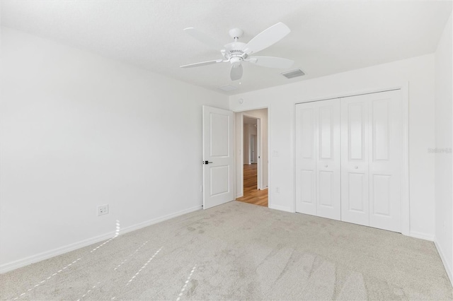 unfurnished bedroom with a closet, ceiling fan, and light colored carpet