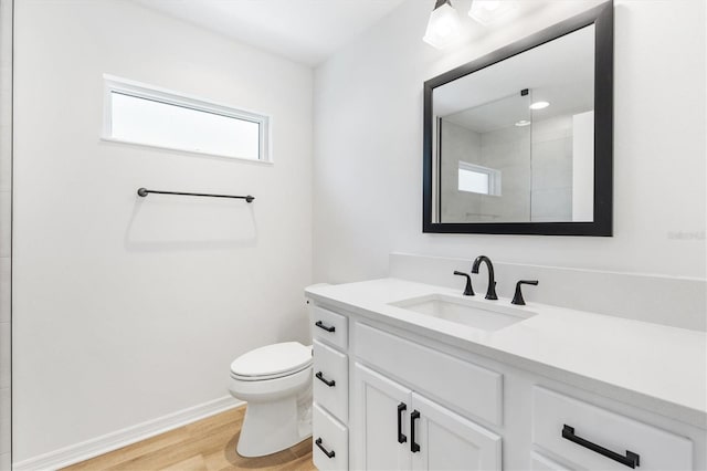 bathroom with hardwood / wood-style floors, vanity, and toilet