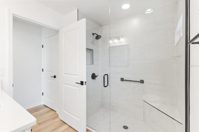 bathroom with hardwood / wood-style floors and walk in shower