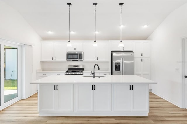 kitchen with lofted ceiling, sink, an island with sink, decorative light fixtures, and stainless steel appliances