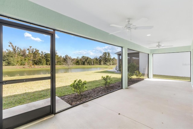 unfurnished sunroom with a water view, ceiling fan, and a healthy amount of sunlight