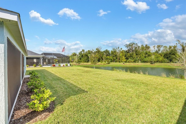 view of yard with a lanai and a water view