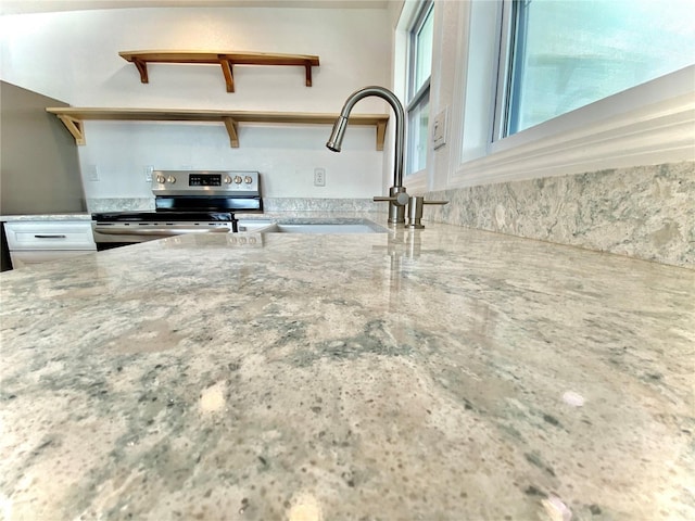 kitchen featuring stainless steel electric range oven and sink