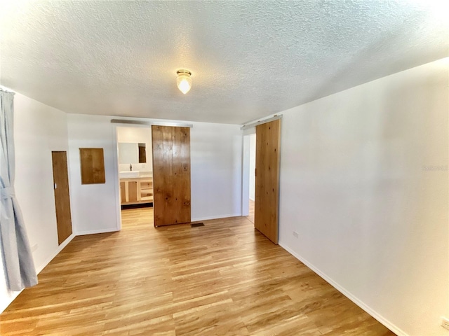 empty room featuring a textured ceiling and light wood-type flooring