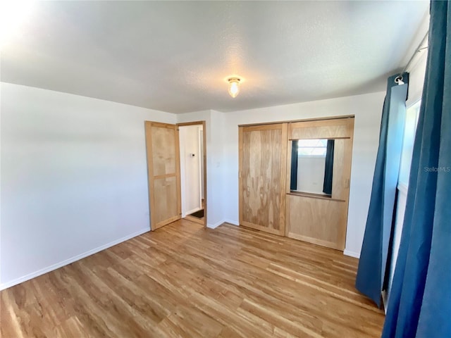 unfurnished bedroom with a closet, a textured ceiling, and hardwood / wood-style flooring