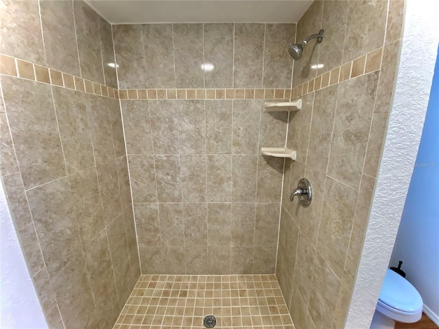 bathroom with tiled shower and toilet