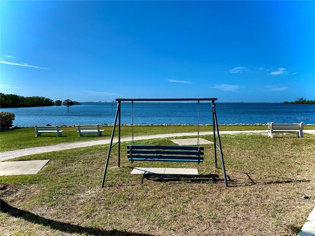 view of home's community featuring a water view and a lawn