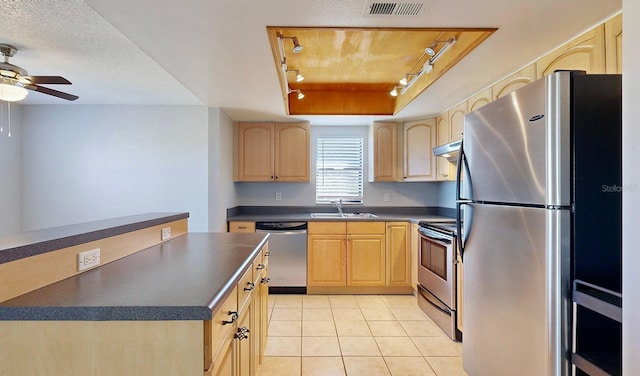 kitchen featuring ceiling fan, sink, rail lighting, stainless steel appliances, and light brown cabinetry