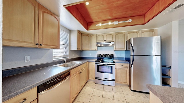 kitchen featuring sink, light tile patterned floors, light brown cabinetry, appliances with stainless steel finishes, and a tray ceiling