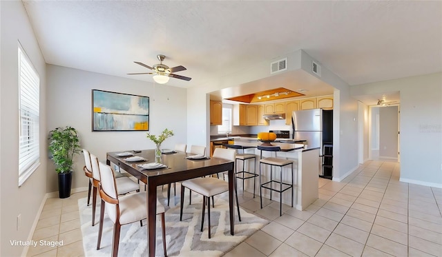 tiled dining room featuring ceiling fan