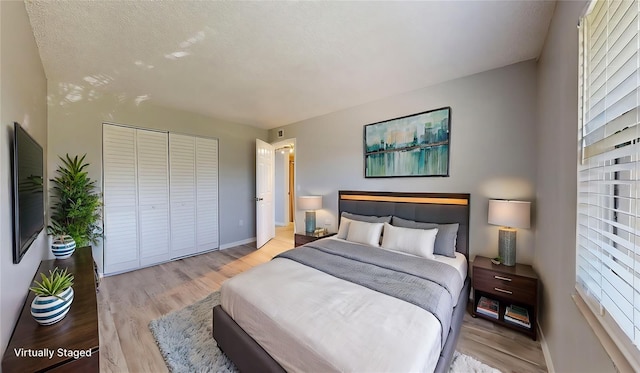 bedroom featuring a closet, a textured ceiling, and light wood-type flooring