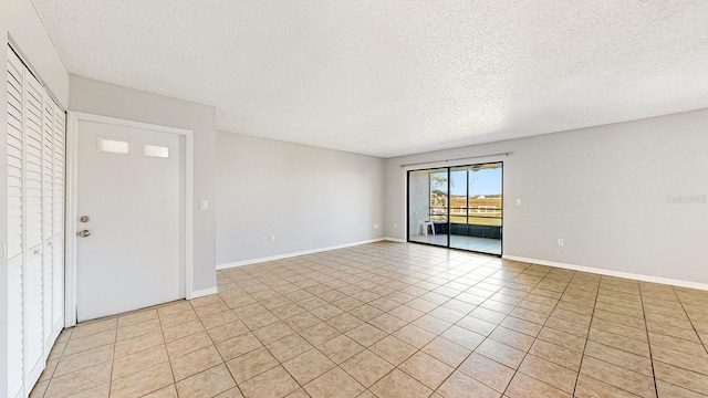 tiled spare room with a textured ceiling