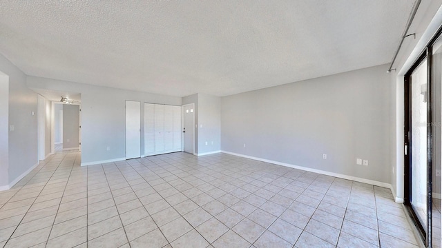 interior space with light tile patterned flooring, a healthy amount of sunlight, and a textured ceiling