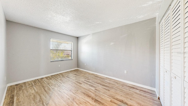 interior space featuring a closet, light hardwood / wood-style flooring, and a textured ceiling