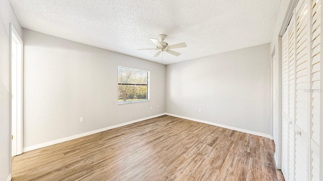 unfurnished room featuring ceiling fan, a textured ceiling, and light wood-type flooring