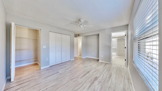 unfurnished bedroom with ensuite bathroom, light hardwood / wood-style floors, a textured ceiling, and ceiling fan