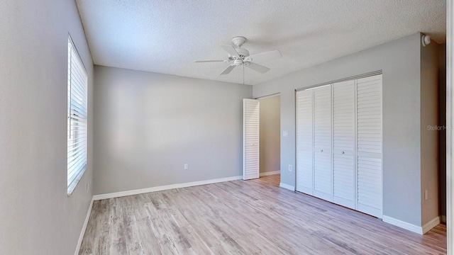 unfurnished bedroom with a closet, ceiling fan, light hardwood / wood-style flooring, and a textured ceiling