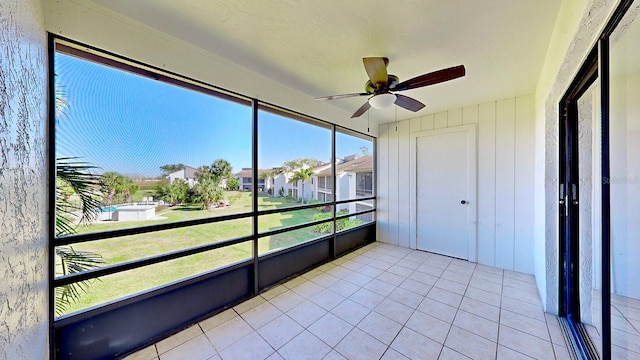 unfurnished sunroom featuring ceiling fan