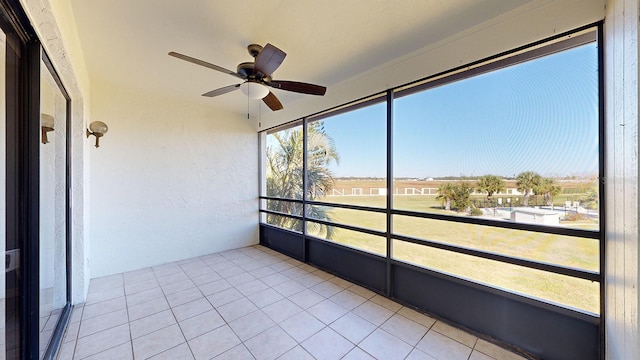 unfurnished sunroom featuring ceiling fan