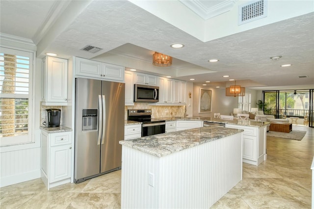 kitchen featuring kitchen peninsula, white cabinetry, pendant lighting, and appliances with stainless steel finishes