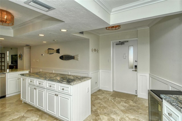 kitchen featuring white cabinetry, crown molding, a kitchen island, and stone countertops