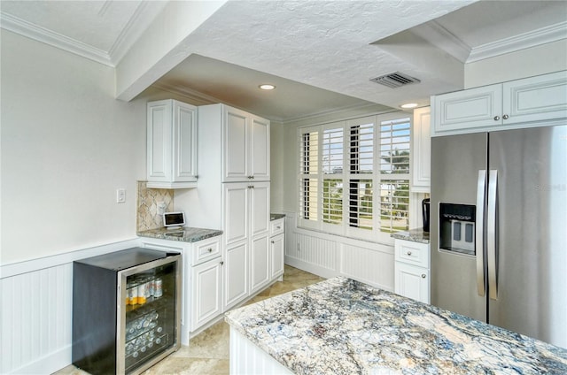 kitchen with stainless steel refrigerator with ice dispenser, white cabinetry, and light stone counters