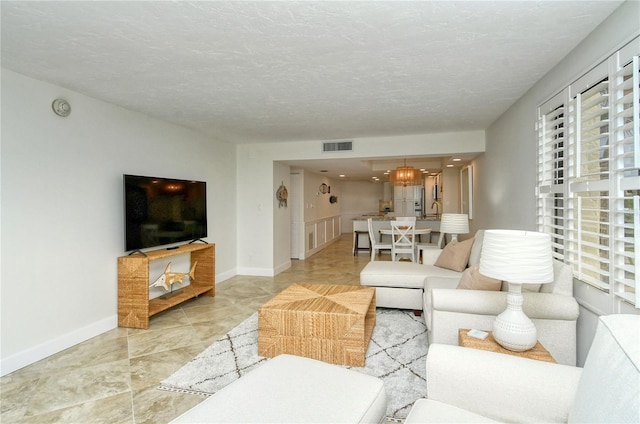 living room featuring a chandelier and a textured ceiling