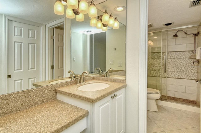 bathroom featuring tile patterned floors, vanity, tiled shower, tile walls, and toilet