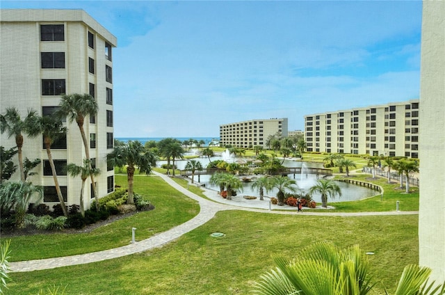 view of community featuring a lawn and a water view