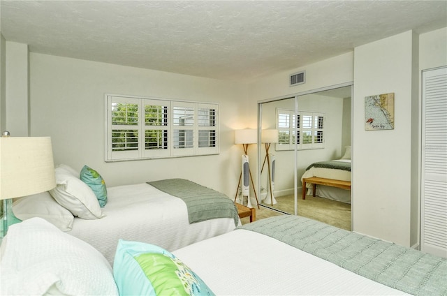 carpeted bedroom featuring multiple windows and a textured ceiling