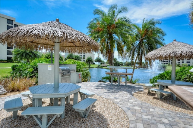 view of patio with grilling area and a water view