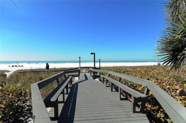 view of dock featuring a view of the beach and a water view