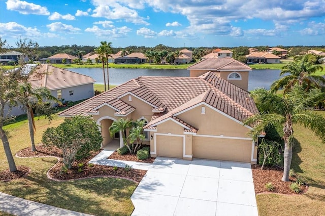 view of front of property featuring a garage, a water view, and a front lawn