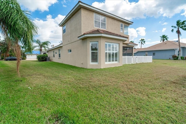 rear view of house with a yard and central AC