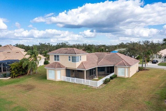 back of property with a lawn and a sunroom