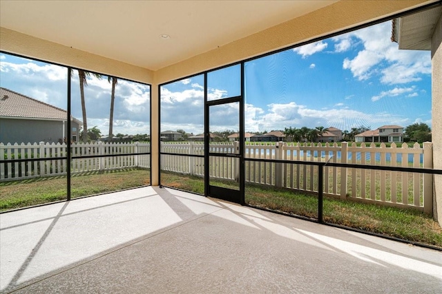 unfurnished sunroom featuring a water view