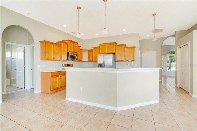 kitchen with pendant lighting, a center island with sink, sink, appliances with stainless steel finishes, and light tile patterned flooring