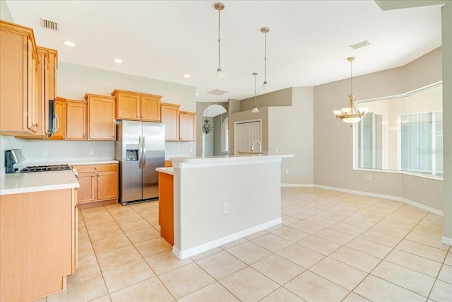 kitchen featuring pendant lighting, light tile patterned floors, an island with sink, and appliances with stainless steel finishes