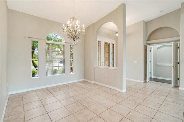 empty room featuring light tile patterned flooring and a chandelier